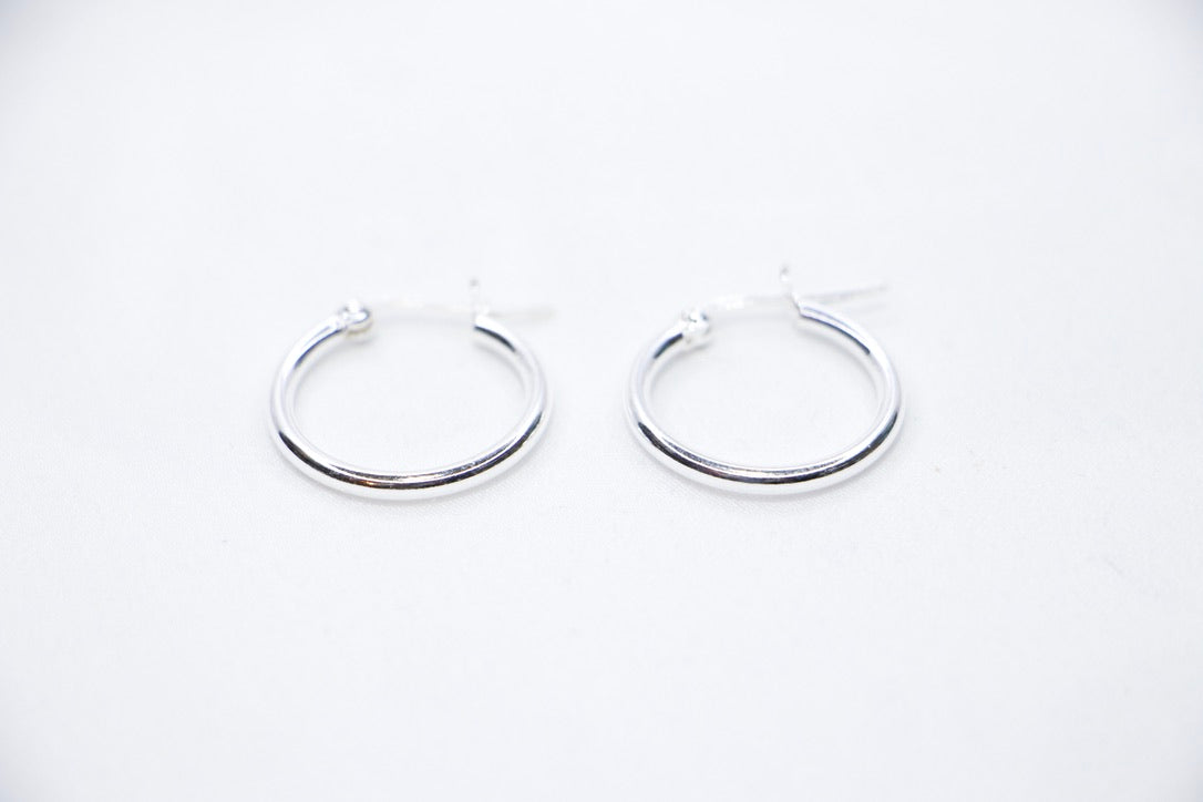 Sterling silver Eternal Grace Hoop Earrings featuring a smooth, polished circular design with an X-shaped closure for a unique, elegant look, front view.