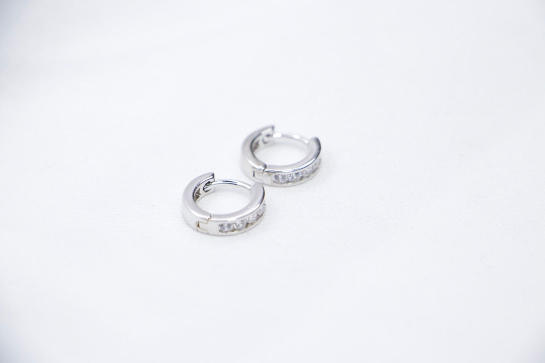 Sterling silver huggie hoop earrings with cubic zirconia, lightweight, hypoallergenic, elegant front view.