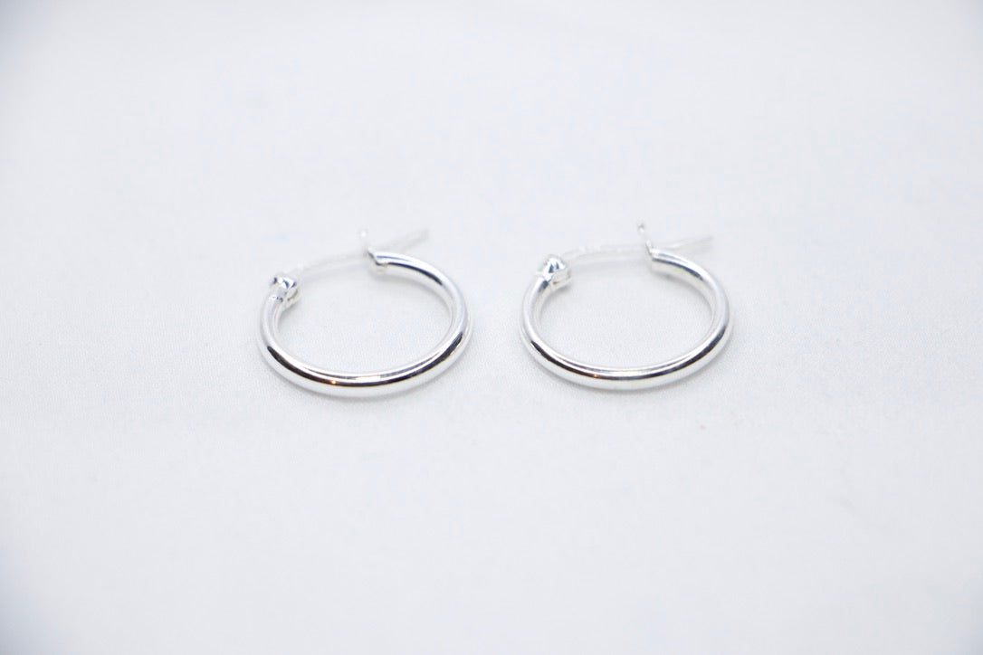 A close-up of sterling silver Radiant Simplicity Hoop Earrings featuring smooth, polished, and circular design for an elegant and classic look front view.