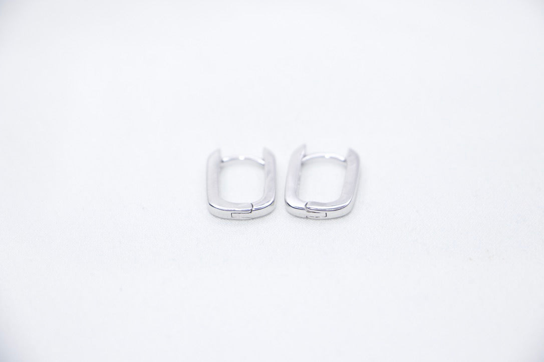 A pair of Sleek Seduction Huggie Hoops in 925 sterling silver, featuring a modern rectangular design with a high-polish finish, front view.
