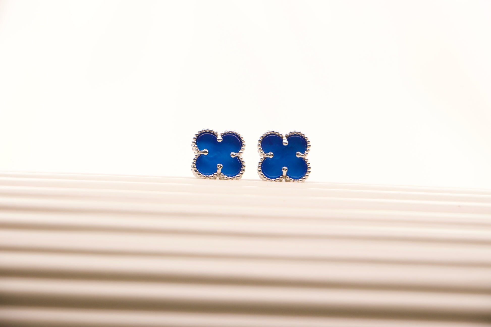 Sterling silver clover earrings with emerald blue enamel, hypoallergenic luxury studs for women.