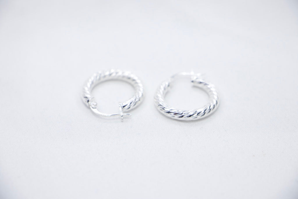 A Braided Radiance Hoop Earrings in sterling silver, featuring a sophisticated braided design that reflects light for a chic and radiant look, sides views. 