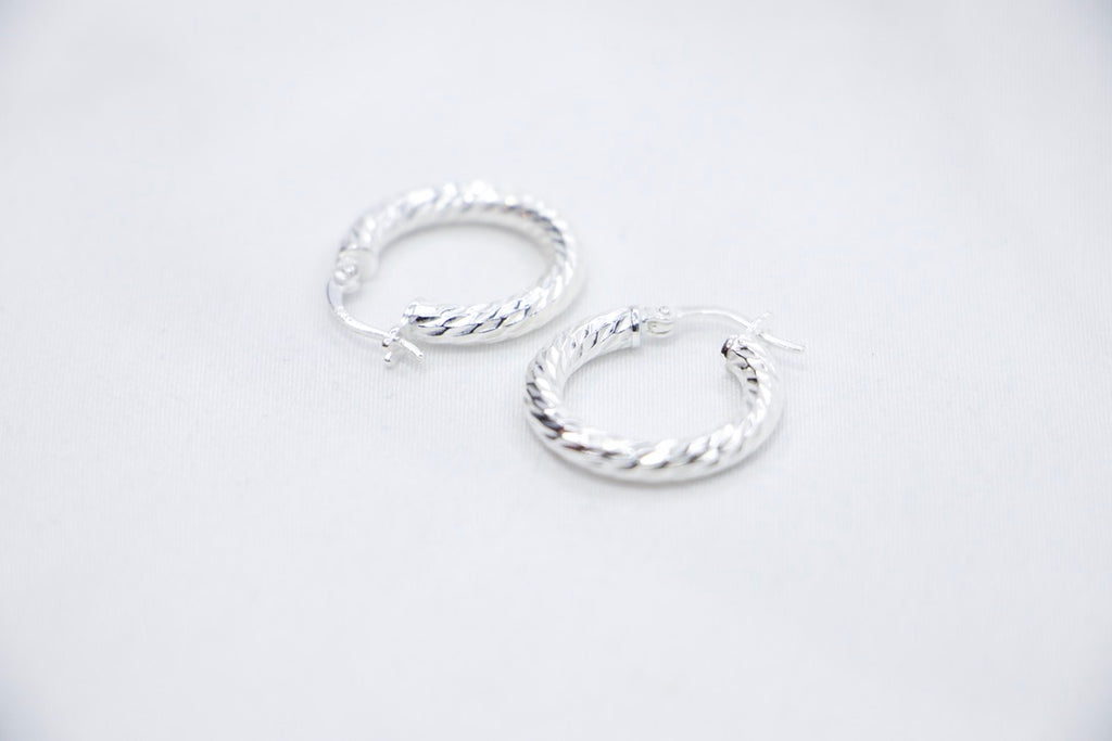A Braided Radiance Hoop Earrings in sterling silver, featuring a sophisticated braided design that reflects light for a chic and radiant look, side views. 