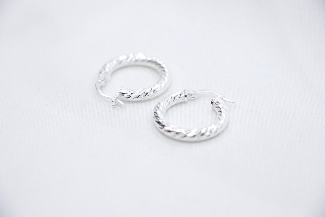 A Braided Radiance Hoop Earrings in sterling silver, featuring a sophisticated braided design that reflects light for a chic and radiant look, side views. 