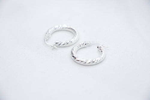 A Braided Radiance Hoop Earrings in sterling silver, featuring a sophisticated braided design that reflects light for a chic and radiant look, side views. 