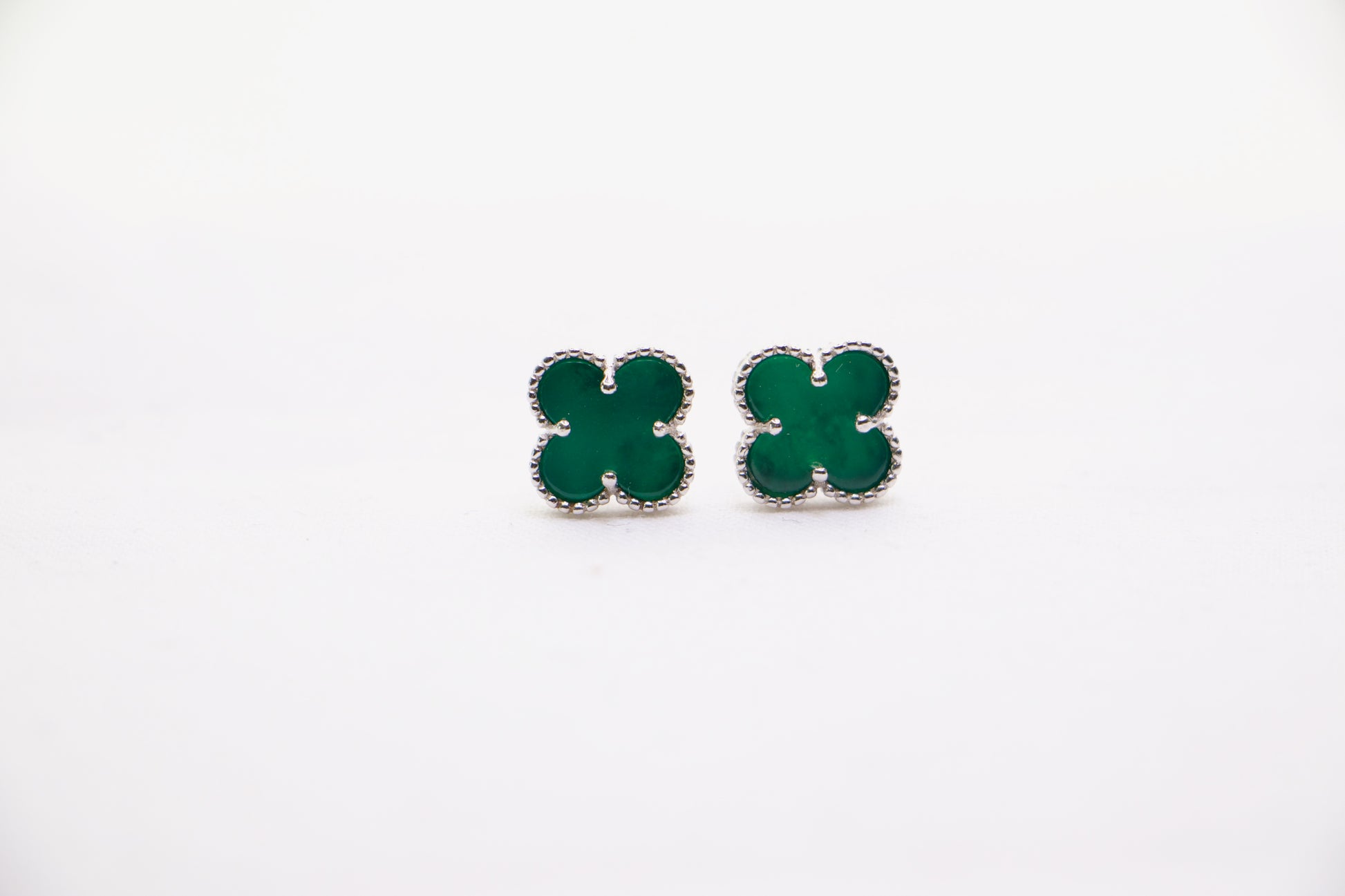 Sterling silver clover earrings with emerald green enamel, hypoallergenic luxury studs for women.