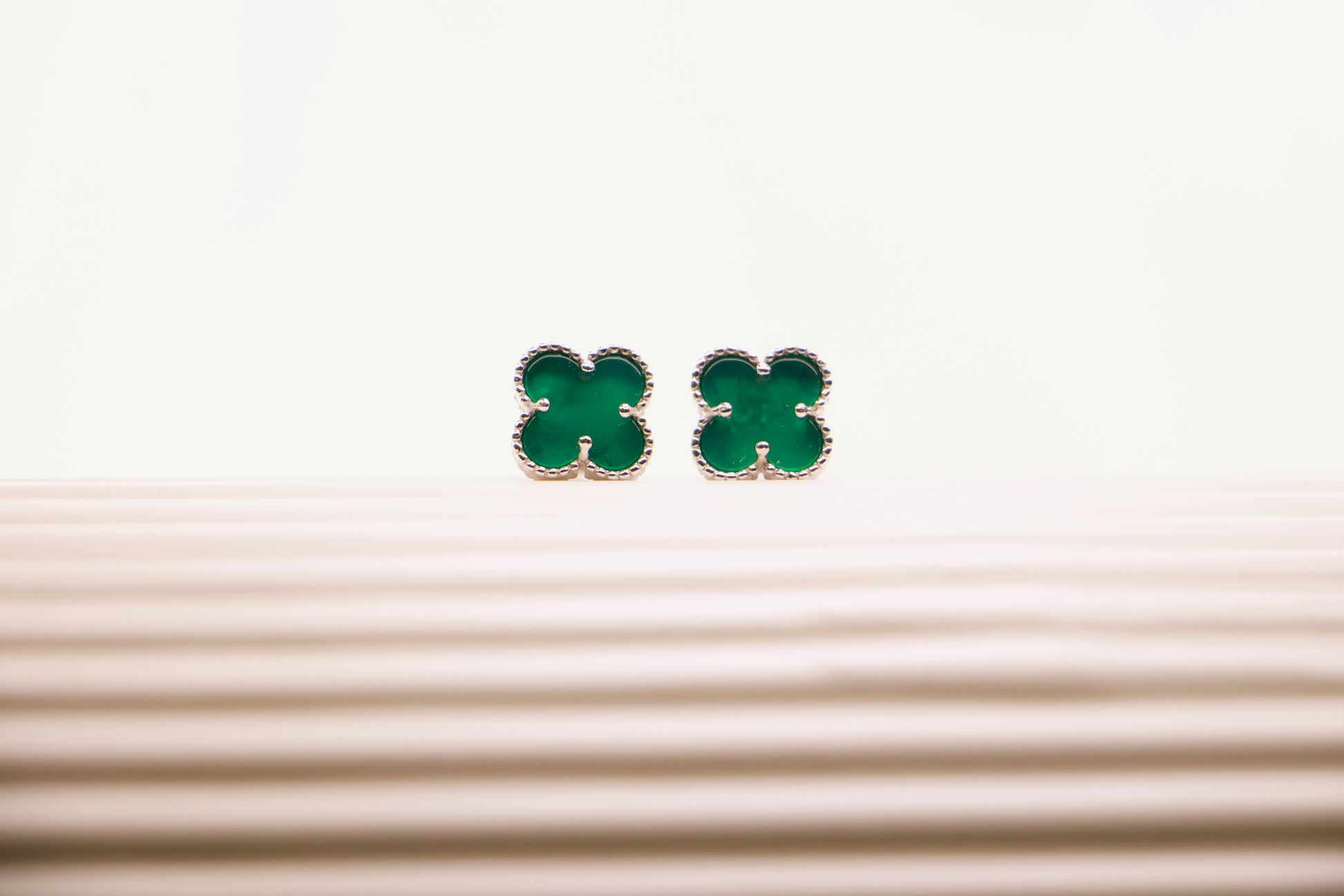 Sterling silver clover earrings with emerald green enamel, hypoallergenic luxury studs for women.