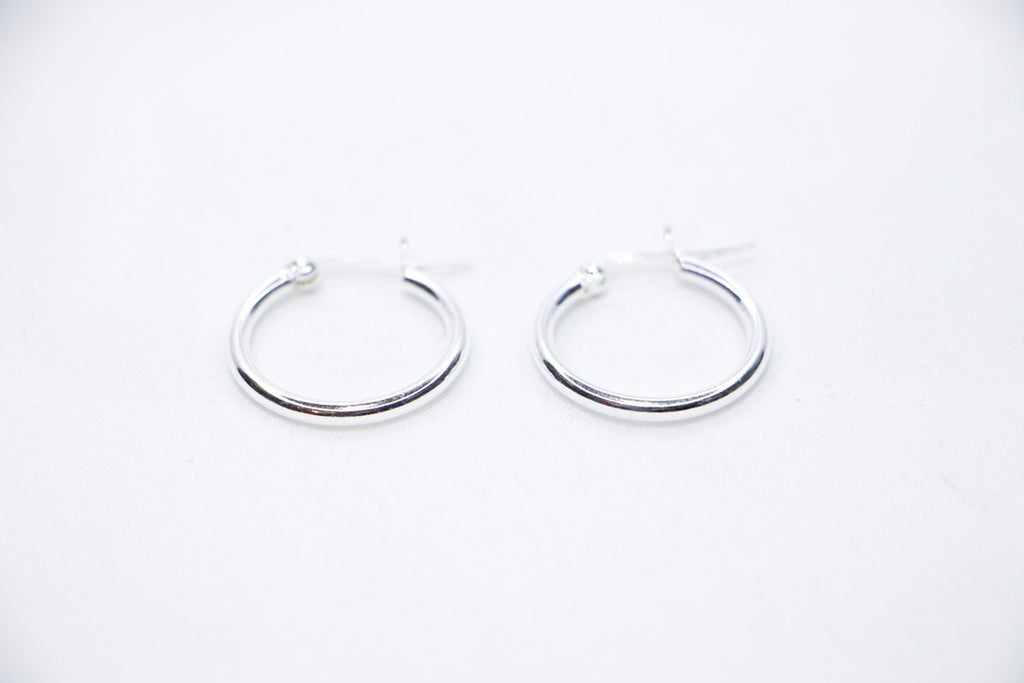 Sterling silver Eternal Grace Hoop Earrings featuring a smooth, polished circular design with an X-shaped closure for a unique, elegant look, front view.