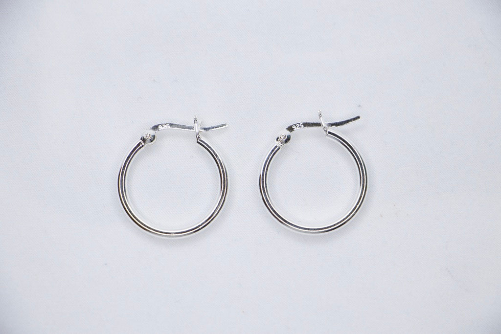 Sterling silver Eternal Grace Hoop Earrings featuring a smooth, polished circular design with an X-shaped closure for a unique, elegant look, top view.