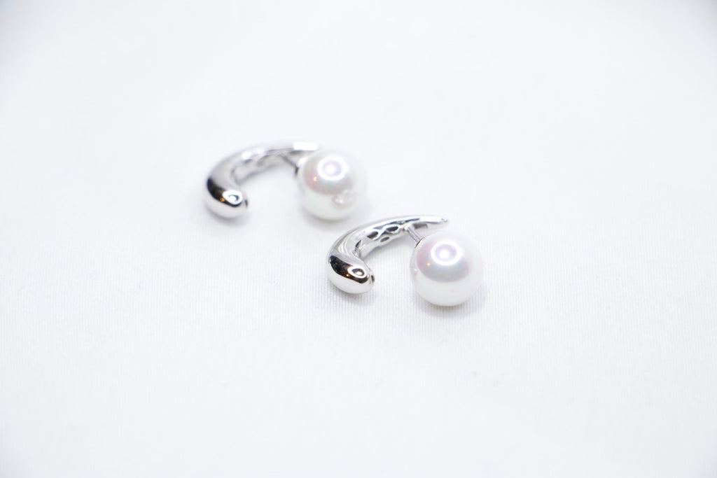 White gold pearl earrings, minimalist design, elegant, timeless, unique, and sophisticated front side right view.