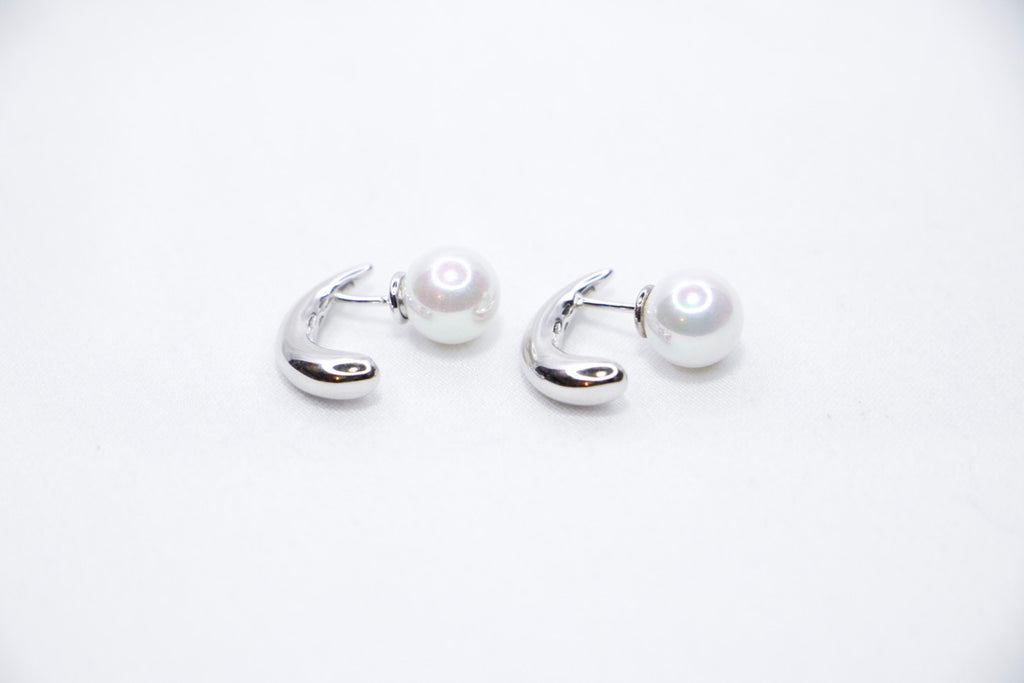 White gold pearl earrings, minimalist design, elegant, timeless, unique, and sophisticated front side left view.