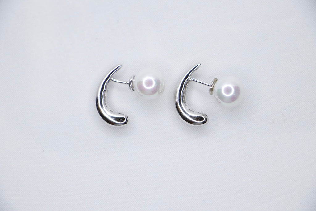 White gold pearl earrings, minimalist design, elegant, timeless, unique, and sophisticated top view.