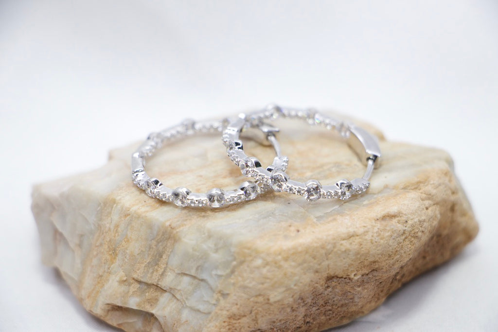 A pair of Lustrous Luxe Hoop Earrings crafted from 925 sterling silver, featuring bezel-set cubic zirconia stones in a sleek, lightweight hoop design, rock view.