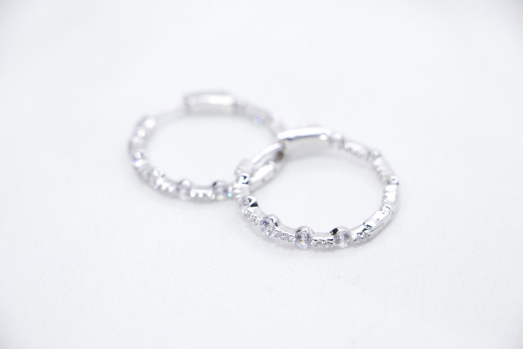 A pair of Lustrous Luxe Hoop Earrings crafted from 925 sterling silver, featuring bezel-set cubic zirconia stones in a sleek, lightweight hoop design, sides view.