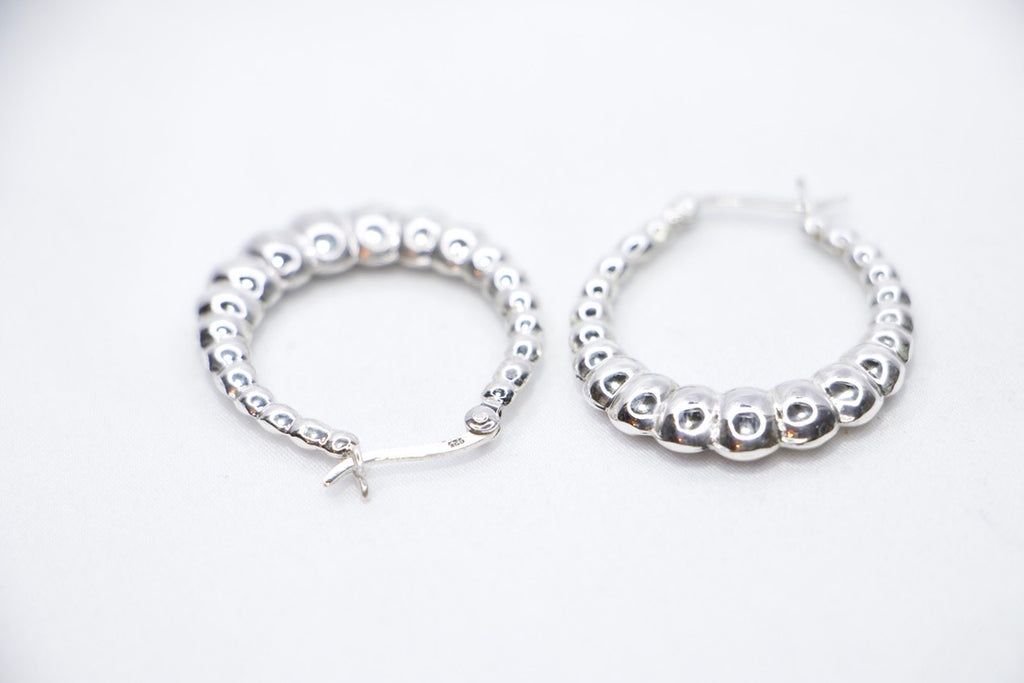Lustrous Ripple Hoops in 925 sterling silver, featuring a sculpted, bubble-textured design with a high-polish finish, side view. 