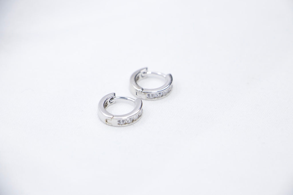 Sterling silver huggie hoop earrings with cubic zirconia, lightweight, hypoallergenic, elegant front view.