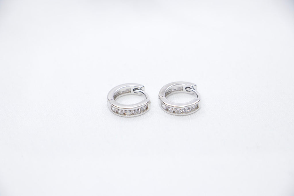 Sterling silver huggie hoop earrings with cubic zirconia, lightweight, hypoallergenic, elegant front side view.