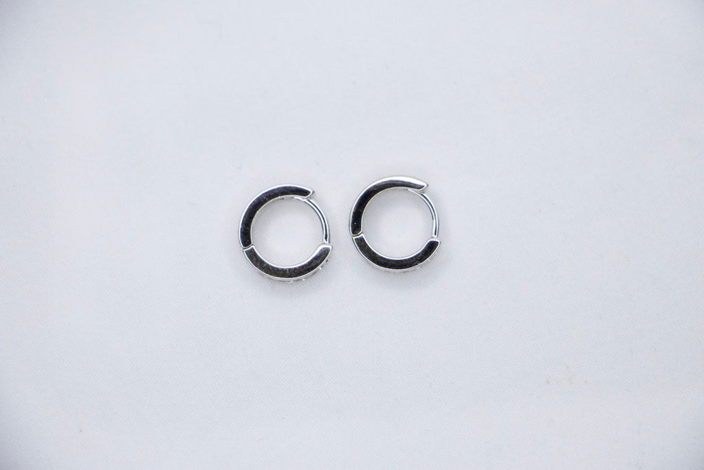 Sterling silver huggie hoop earrings with cubic zirconia, lightweight, hypoallergenic, elegant top view.