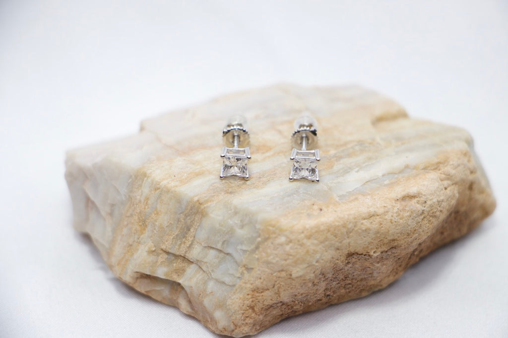 A Radiant Luxe Stud Earrings featuring a rectangular-cut cubic zirconia set in sterling silver, offering a modern and radiant look, rock view.