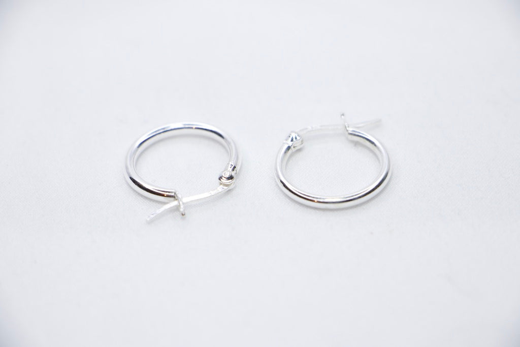 A close-up of sterling silver Radiant Simplicity Hoop Earrings featuring smooth, polished, and circular design for an elegant and classic look sides view.