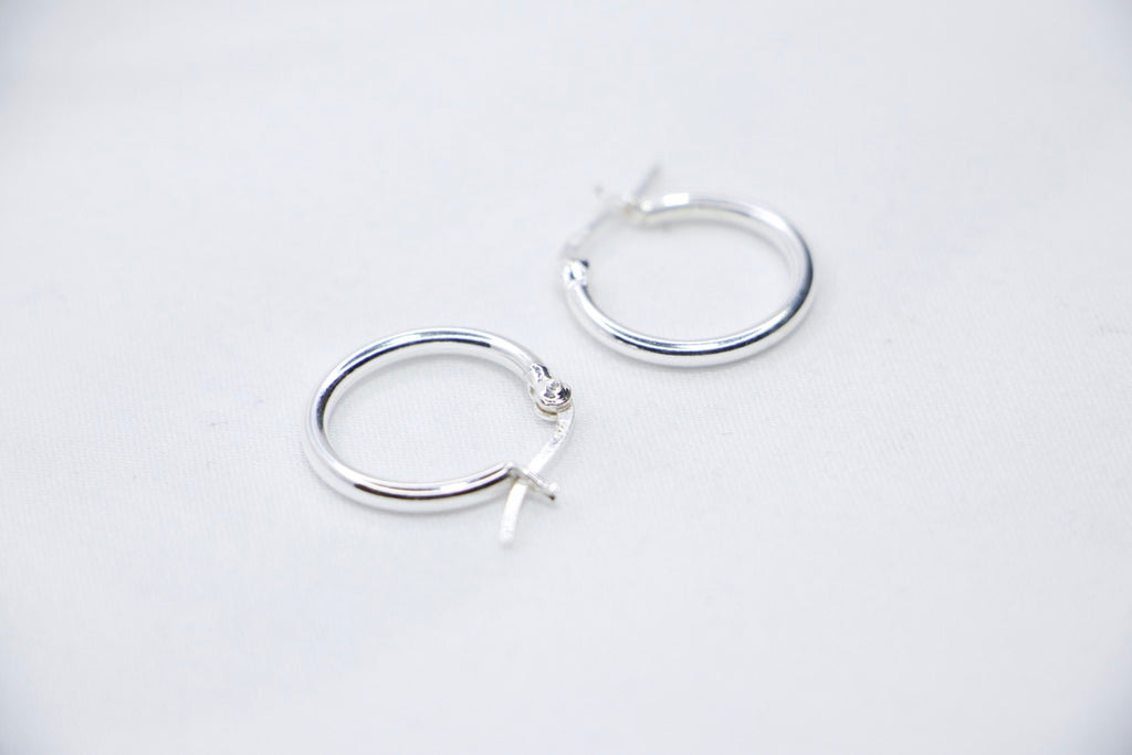 A close-up of sterling silver Radiant Simplicity Hoop Earrings featuring smooth, polished, and circular design for an elegant and classic look sides view.