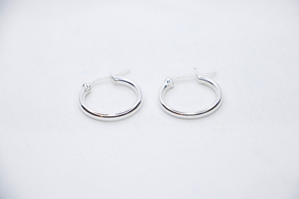 A close-up of sterling silver Radiant Simplicity Hoop Earrings featuring smooth, polished, and circular design for an elegant and classic look front view.