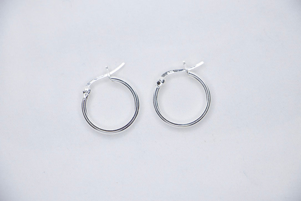 A close-up of sterling silver Radiant Simplicity Hoop Earrings featuring smooth, polished, and circular design for an elegant and classic look top view.