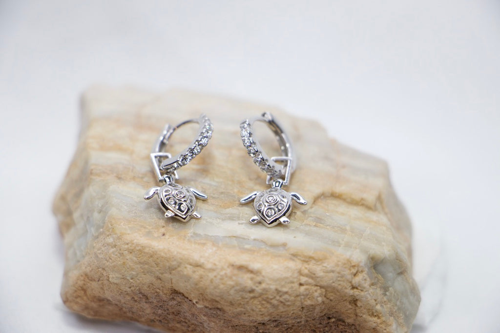 Sea Turtle Hoop Earrings with Cubic Zirconia and Sterling Silver Charm Jewelry for Women top view on rock.