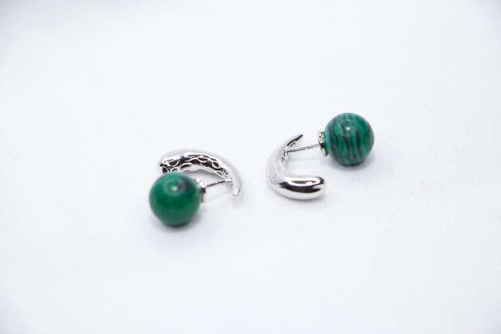 Close-up of Serpentine Dream Malachite Earrings featuring vibrant green malachite spheres set in a curved view.