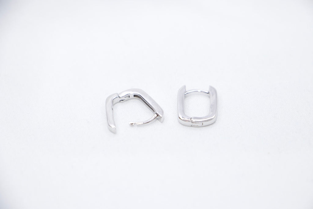 A pair of Sleek Seduction Huggie Hoops in 925 sterling silver, featuring a modern rectangular design with a high-polish finish, open view.