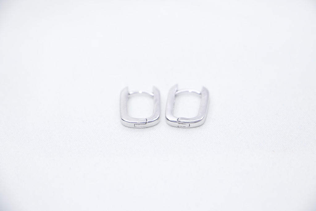 A pair of Sleek Seduction Huggie Hoops in 925 sterling silver, featuring a modern rectangular design with a high-polish finish, front view.
