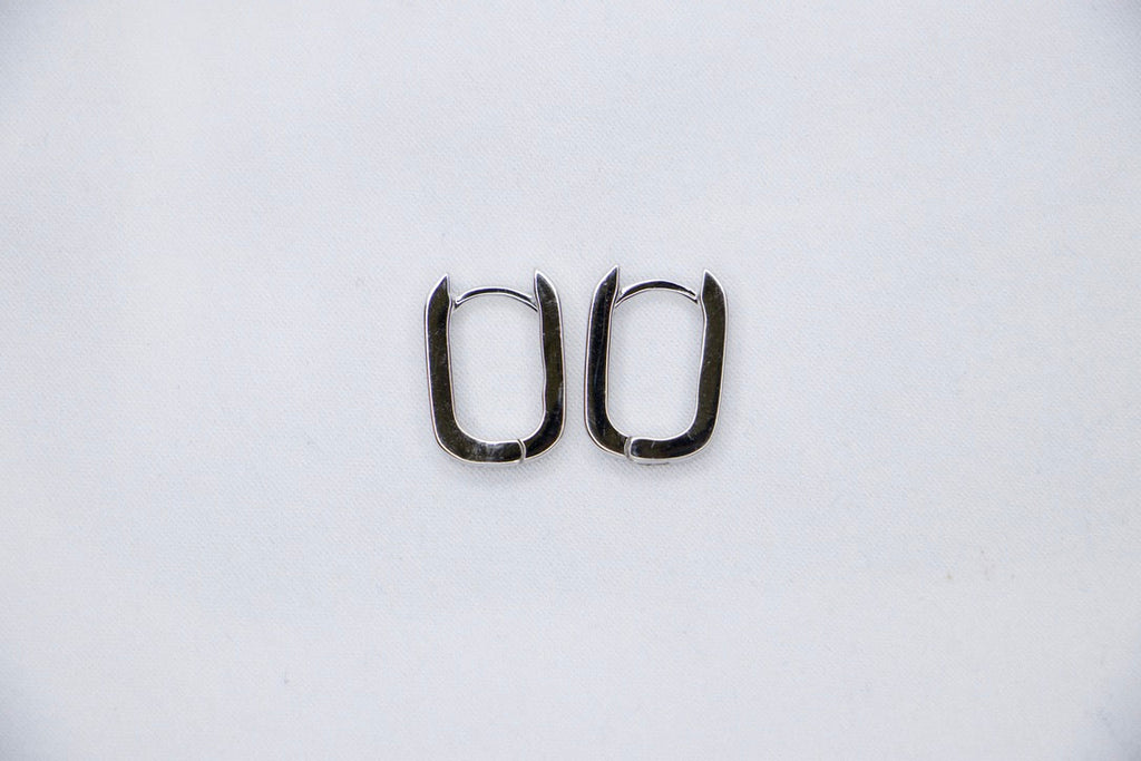 A pair of Sleek Seduction Huggie Hoops in 925 sterling silver, featuring a modern rectangular design with a high-polish finish, front top view.