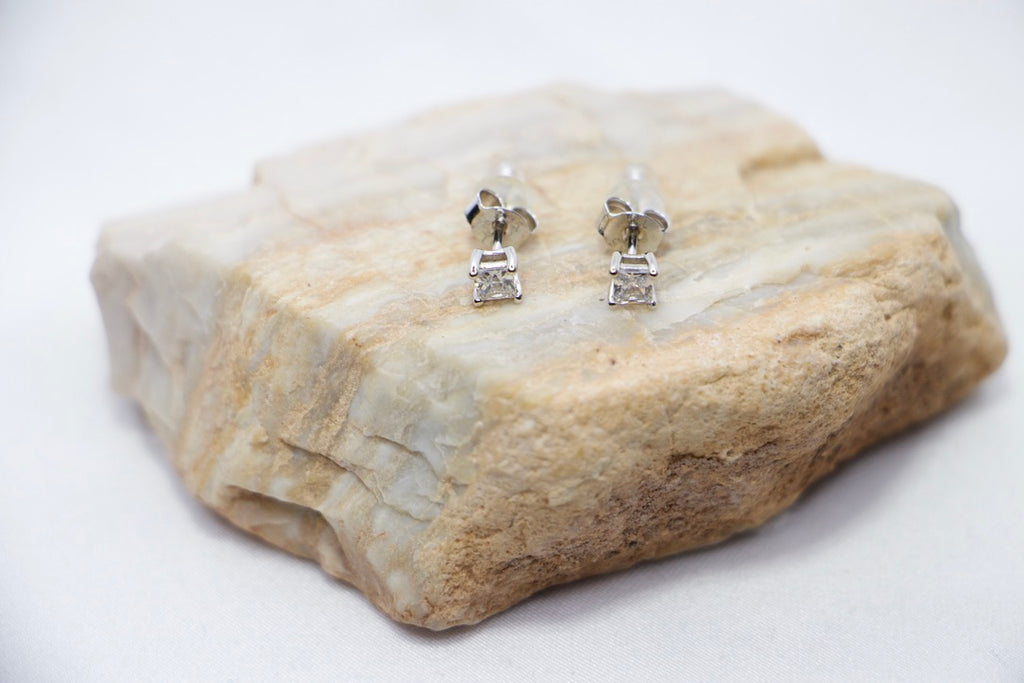 Timeless Sparkle Stud Earrings featuring square-cut cubic zirconia stones set in sterling silver with a radiant sparkle, front rock view.