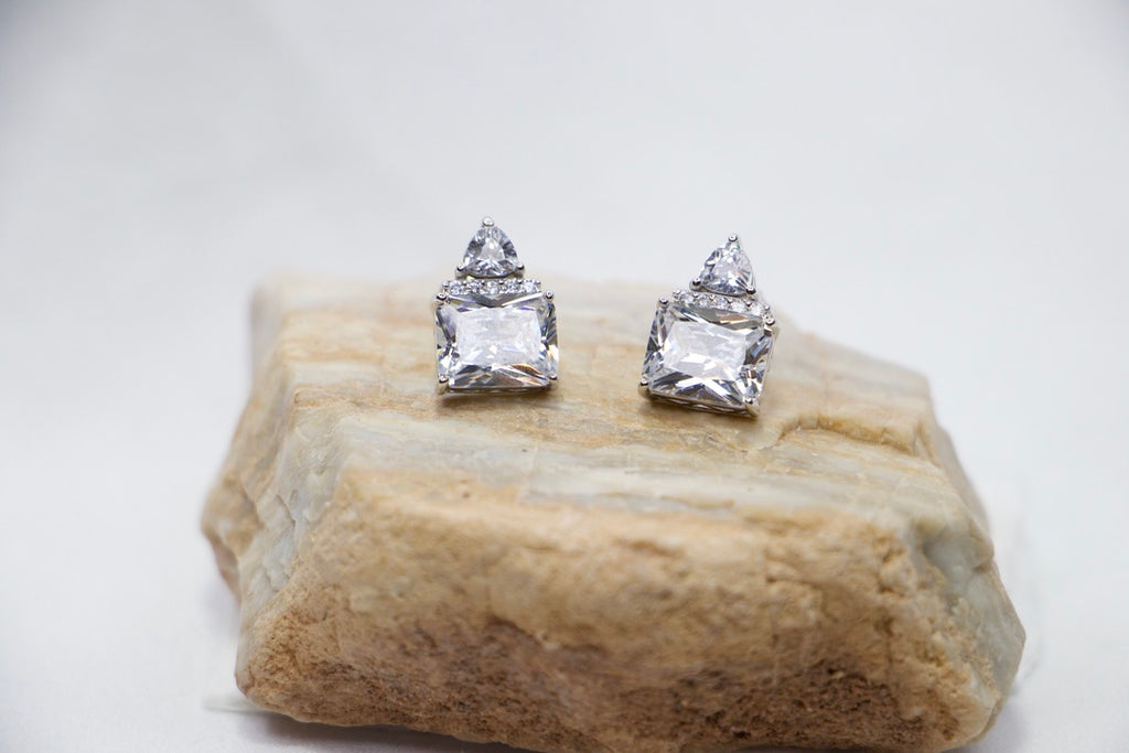 Triple Stone Cubic Zirconia Stud Earrings with Sparkling Statement Jewelry for Women front view on rock.