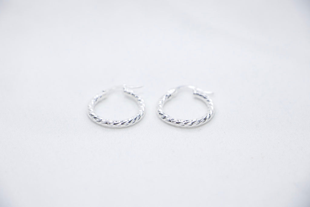 Twisted Charm Hoop Earrings in sterling silver featuring a beautifully twisted design, creating a dynamic texture  front view.