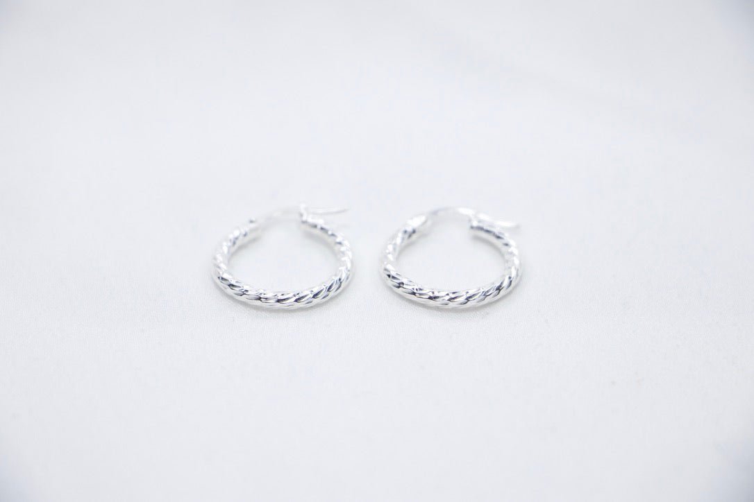 Twisted Charm Hoop Earrings in sterling silver featuring a beautifully twisted design, creating a dynamic texture  front view.