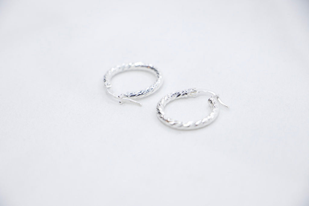 Twisted Charm Hoop Earrings in sterling silver featuring a beautifully twisted design, creating a dynamic texture side views.